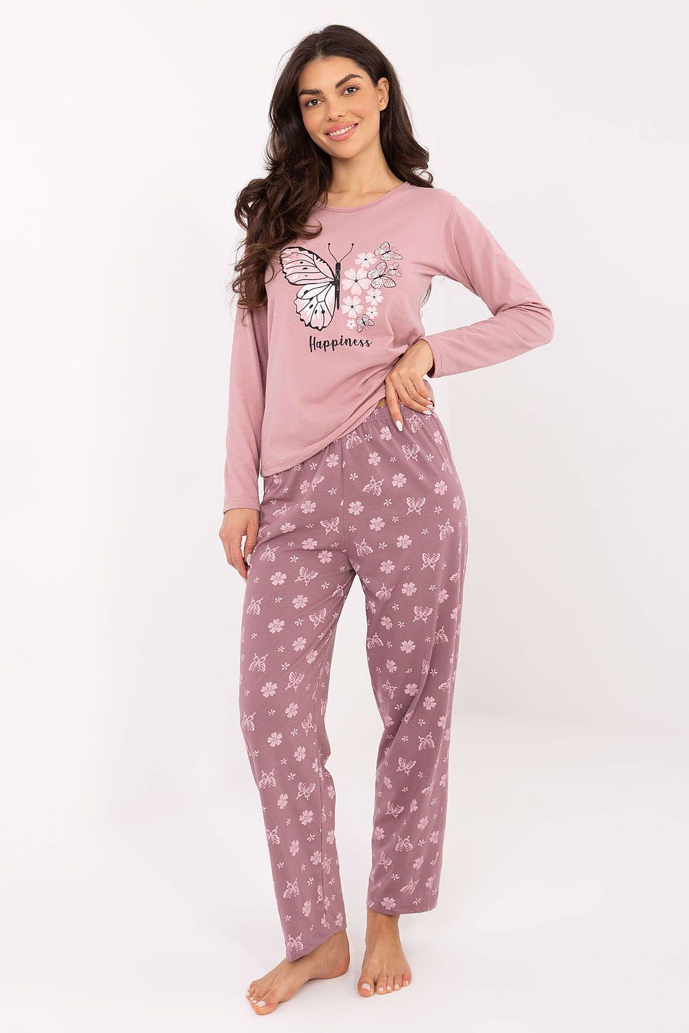 Woman wearing pink butterfly-themed pajamas on a white background