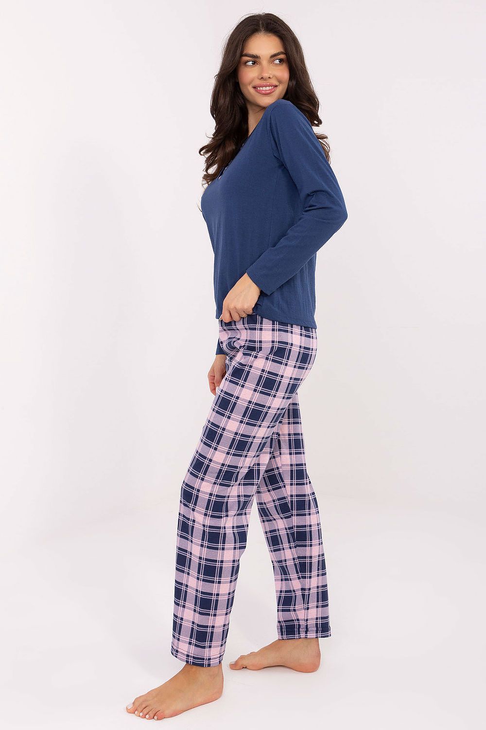 Woman wearing a blue top and plaid pants on a white background