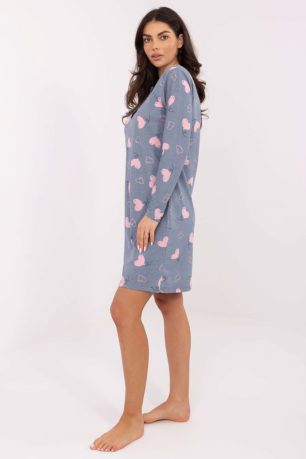 Woman wearing a blue nightshirt with pink hearts on a white background