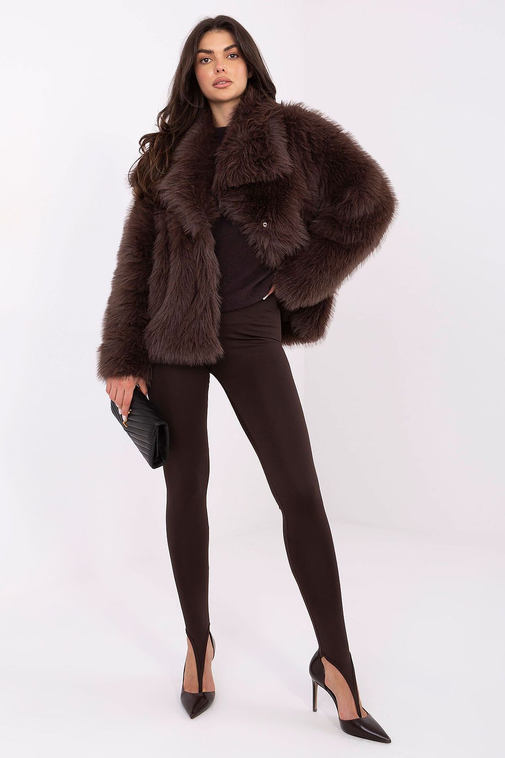 Woman wearing a brown fur coat and black leggings on a white background
