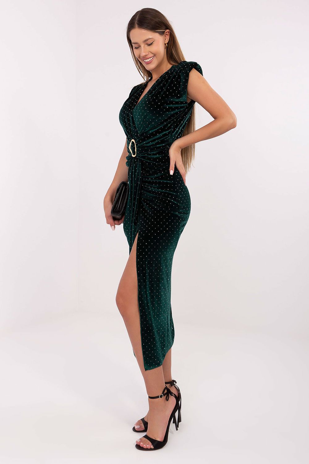 Woman wearing a green dress with a belt on a white background