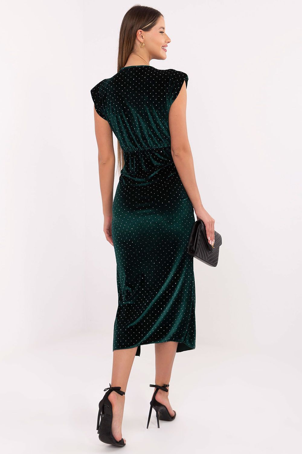 Woman wearing a green dress with black polka dots on a white background