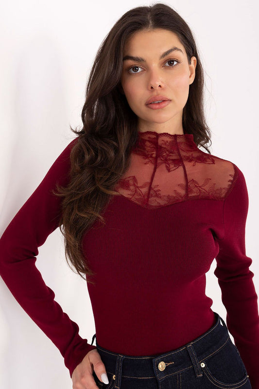 Woman wearing a burgundy long-sleeve top with lace detailing on a white background