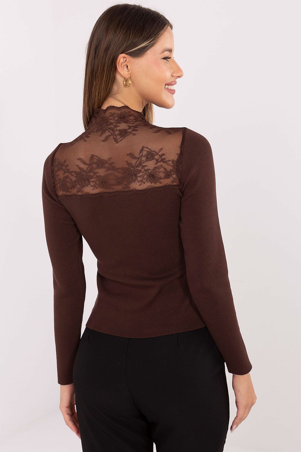 Woman wearing a brown long-sleeve top with lace detailing on a white background