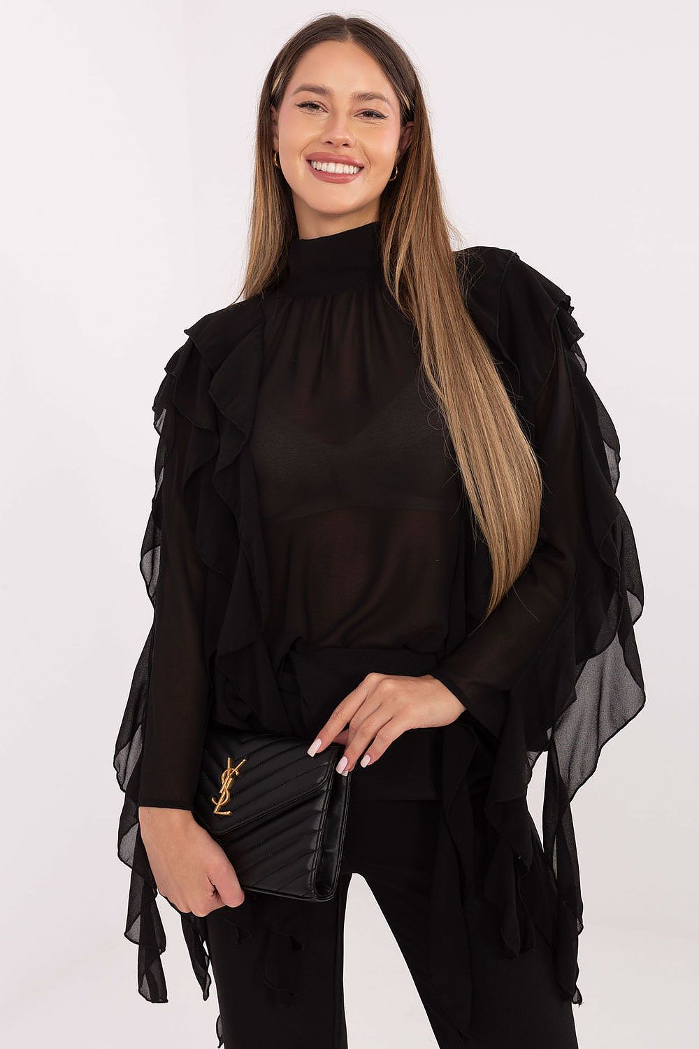 Woman wearing a black outfit with sheer sleeves against a white background