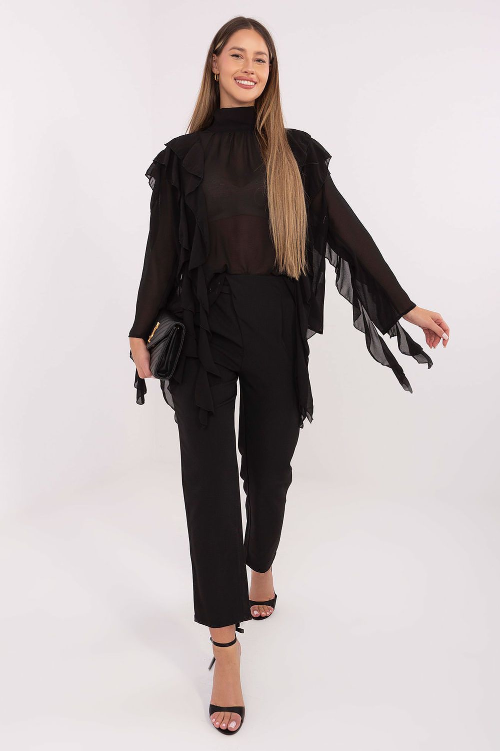 Woman wearing a black outfit with a fringed top on a white background