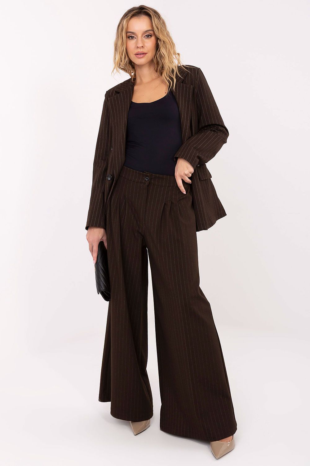 Woman wearing a brown suit with wide-leg pants on a white background