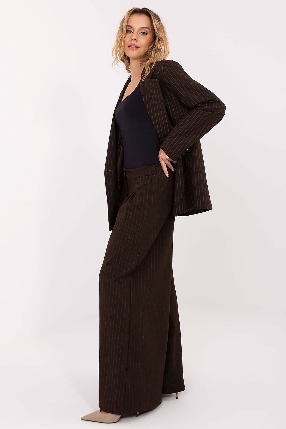 Woman wearing a brown ribbed outfit on a white background