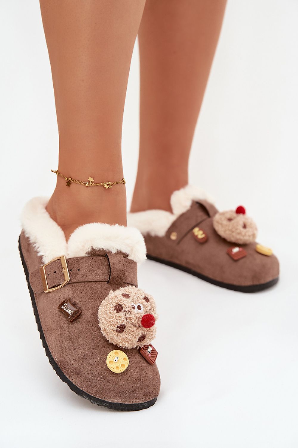 Brown slippers with reindeer decorations on a white background