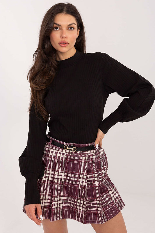 Woman wearing a black sweater and plaid skirt on a white background
