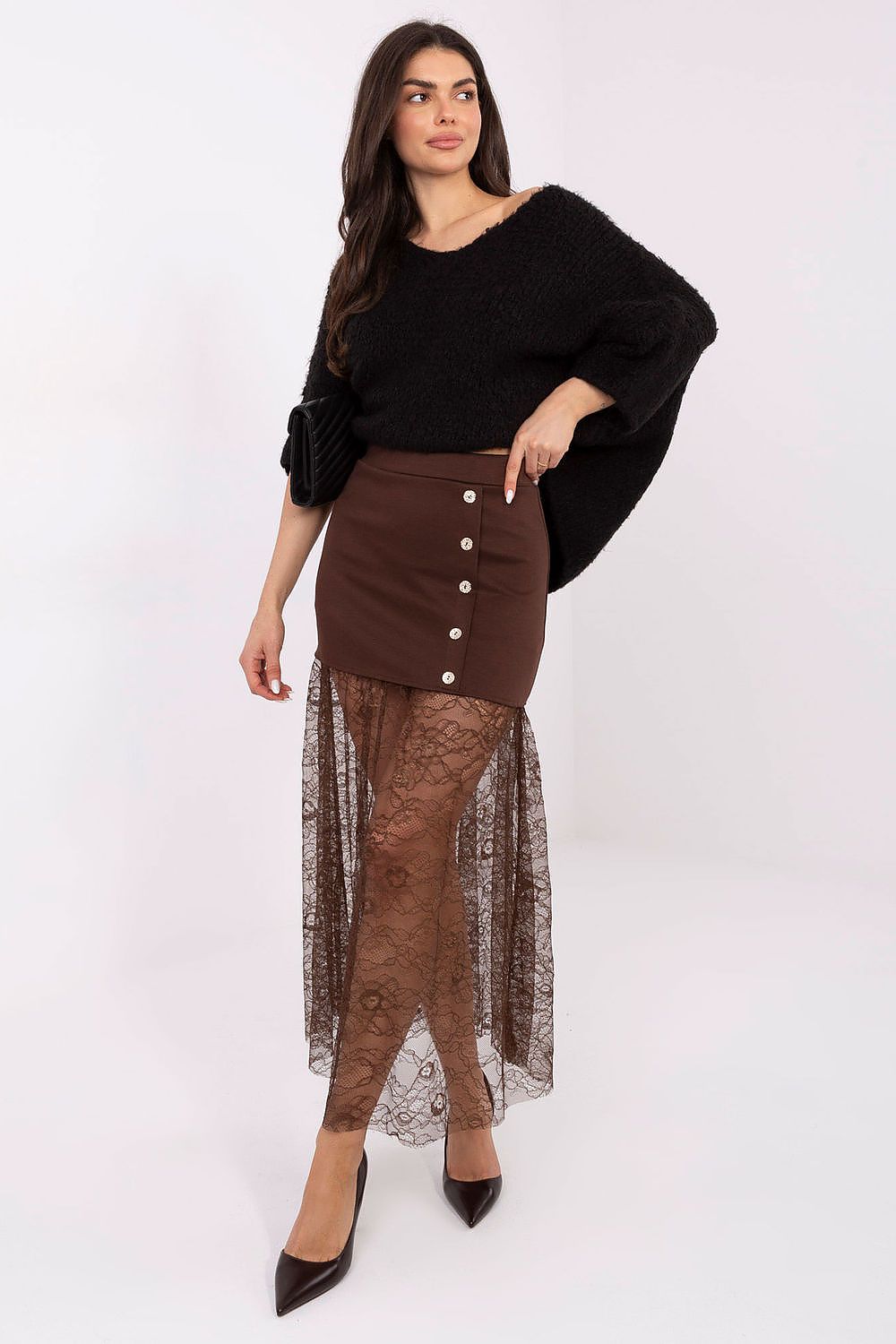 Woman wearing a black top and brown skirt with lace detailing on a white background