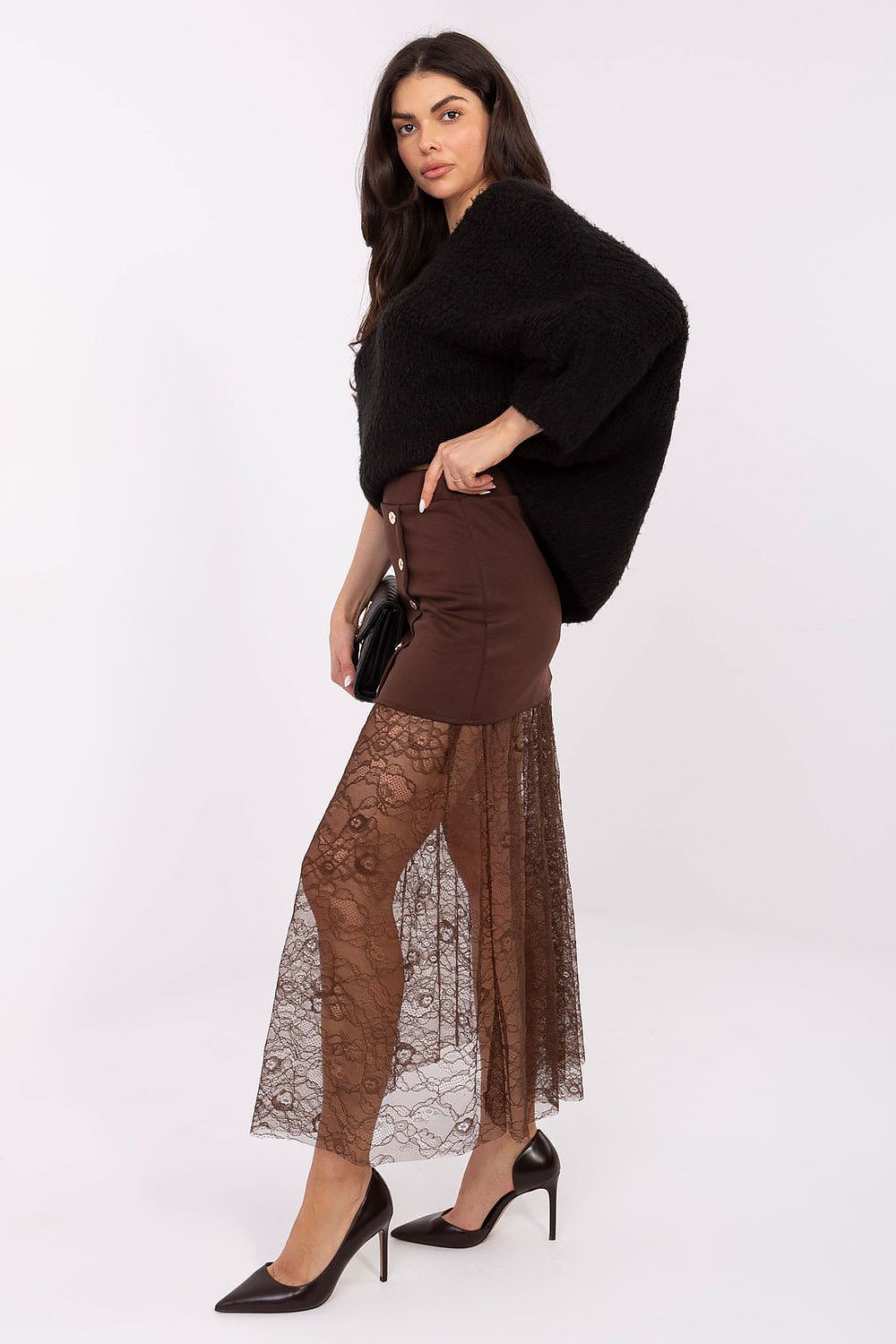 Woman wearing a black sweater, brown lace skirt, and high heels on a white background
