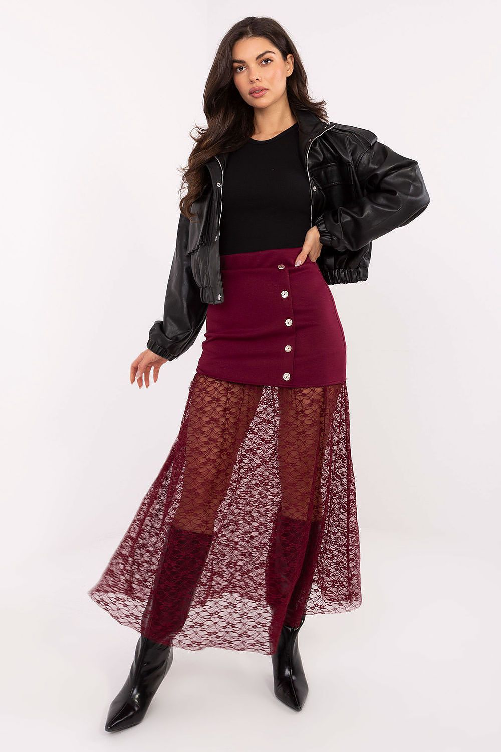 Woman wearing a black jacket, black top, and burgundy skirt with lace overlay on a white background