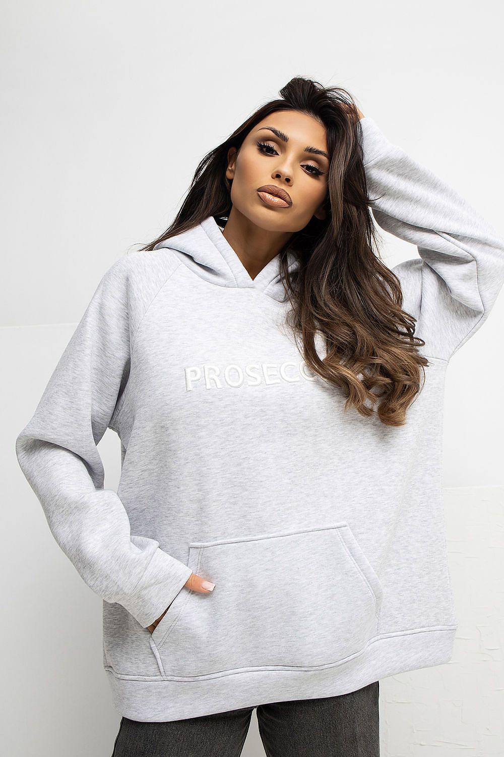 Woman wearing a gray hoodie with 'PROGRESS' text on a white background