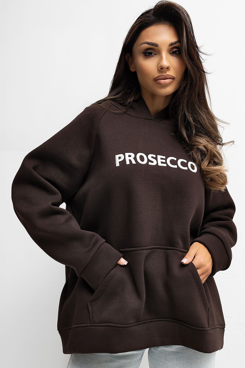 Woman wearing a brown hoodie with 'PROSECCO' text on a white background