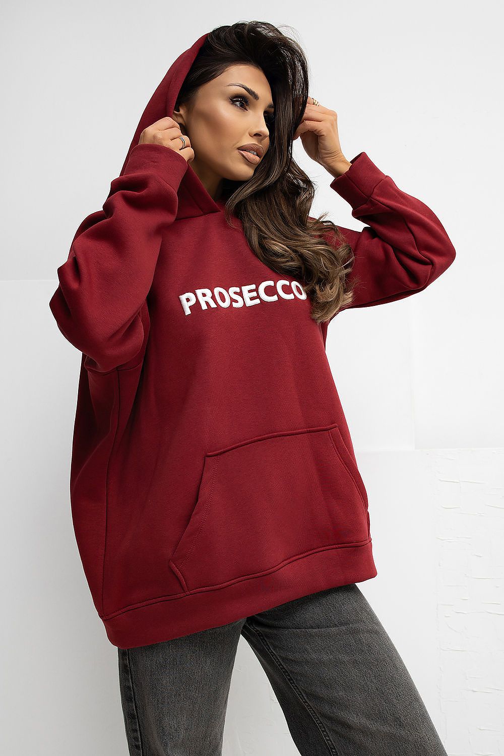 Woman wearing a red hoodie with 'PROSECCO' text on a white background