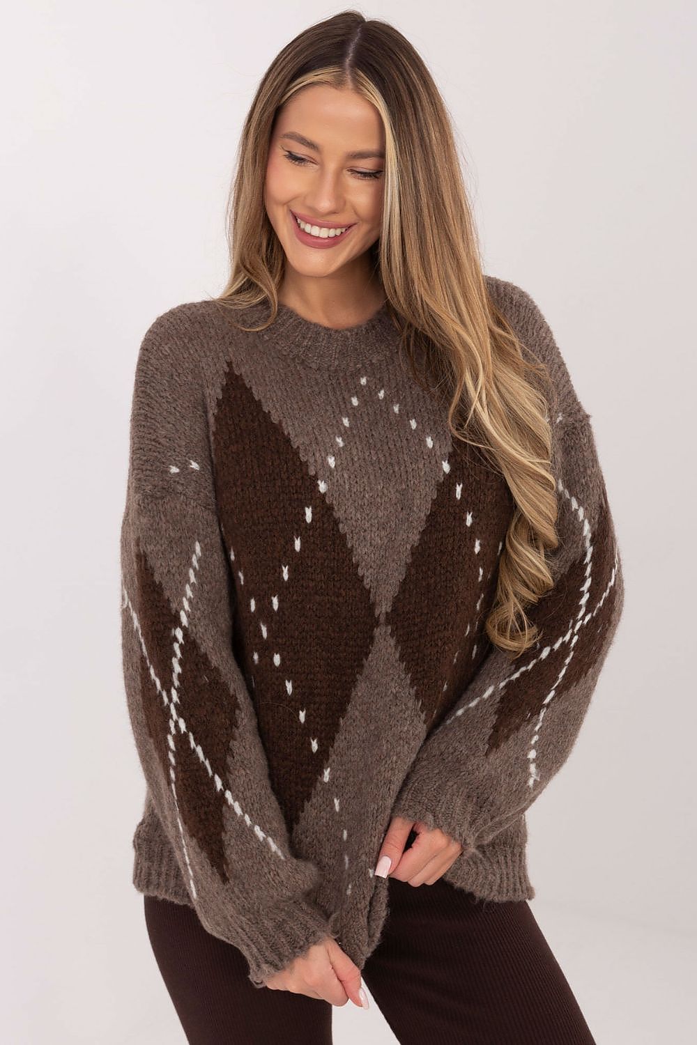 Woman wearing a brown argyle sweater against a white background