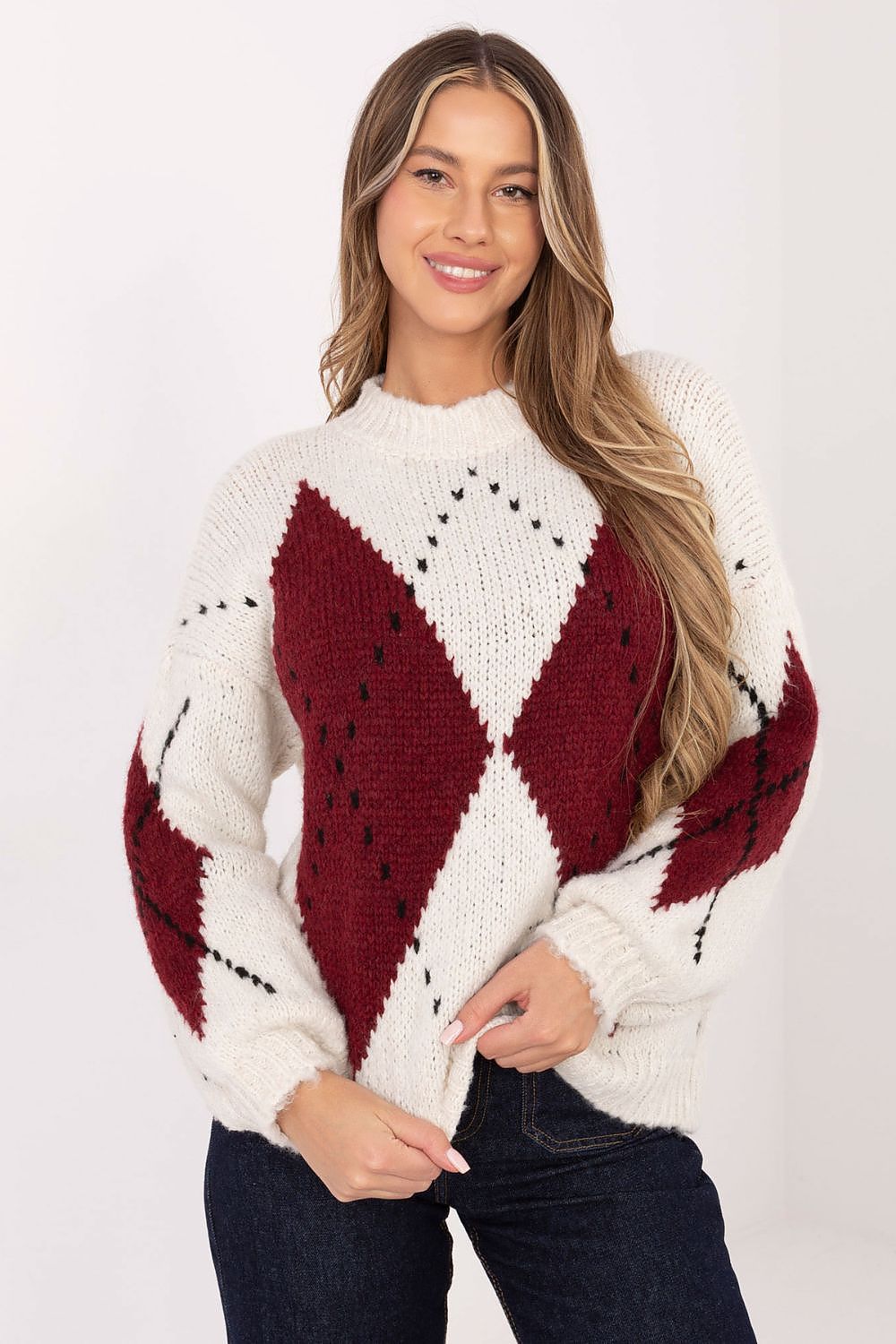 Woman wearing a white sweater with red diamond pattern on a white background