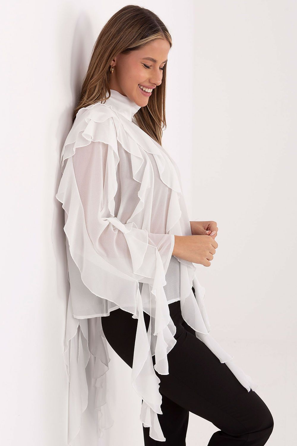 Woman wearing a white sheer blouse over a black outfit against a white background