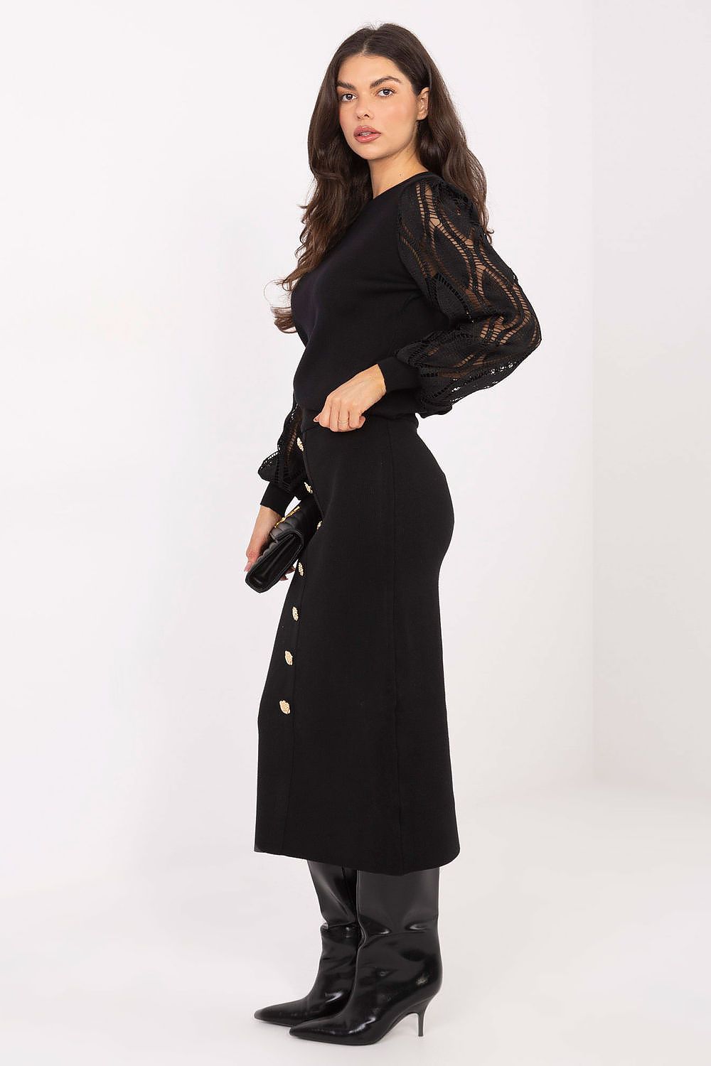 Woman wearing a black outfit with sheer sleeves on a white background