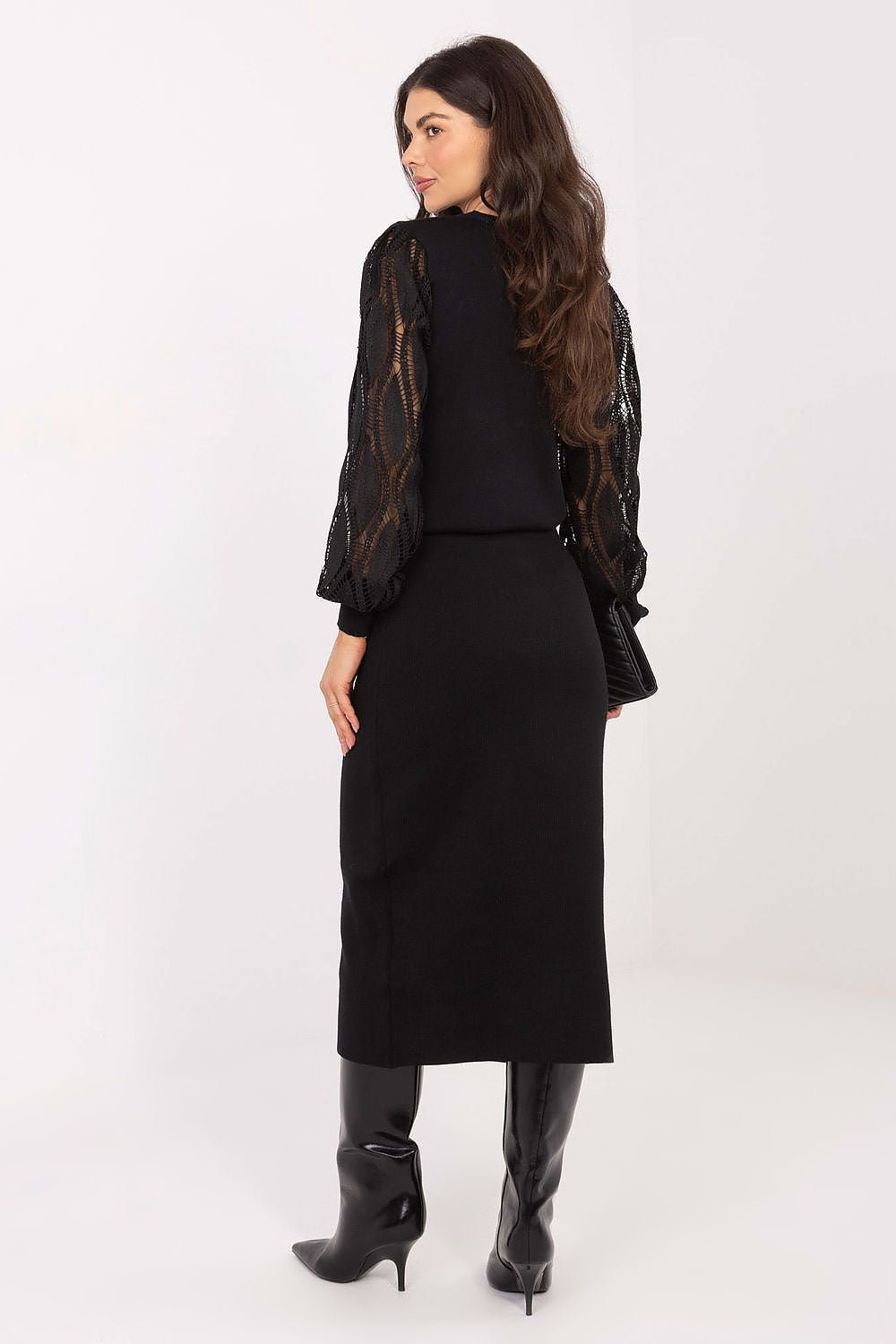 Woman wearing a black outfit with lace sleeves on a white background