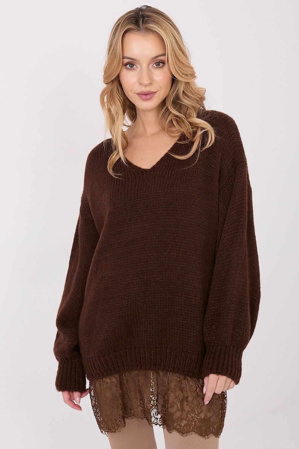 Woman wearing a brown sweater with a lace hem on a white background