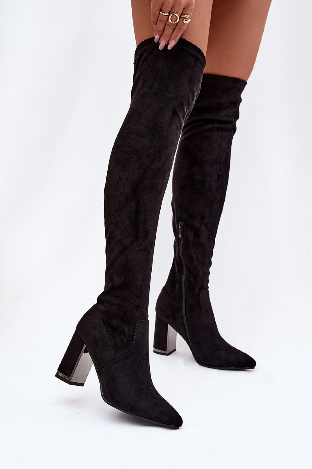 Black suede knee-high boots on a white background