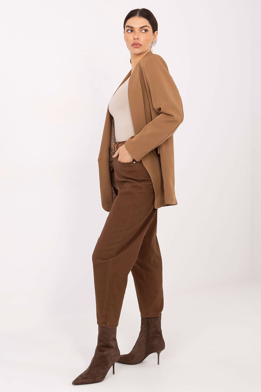 Woman wearing a brown suit with a white top on a white background