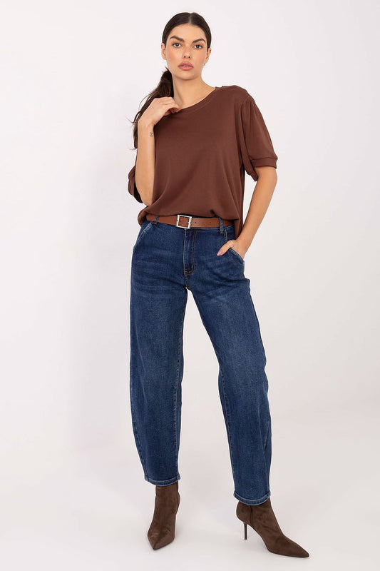 Woman wearing a brown one-shoulder top and blue jeans on a white background