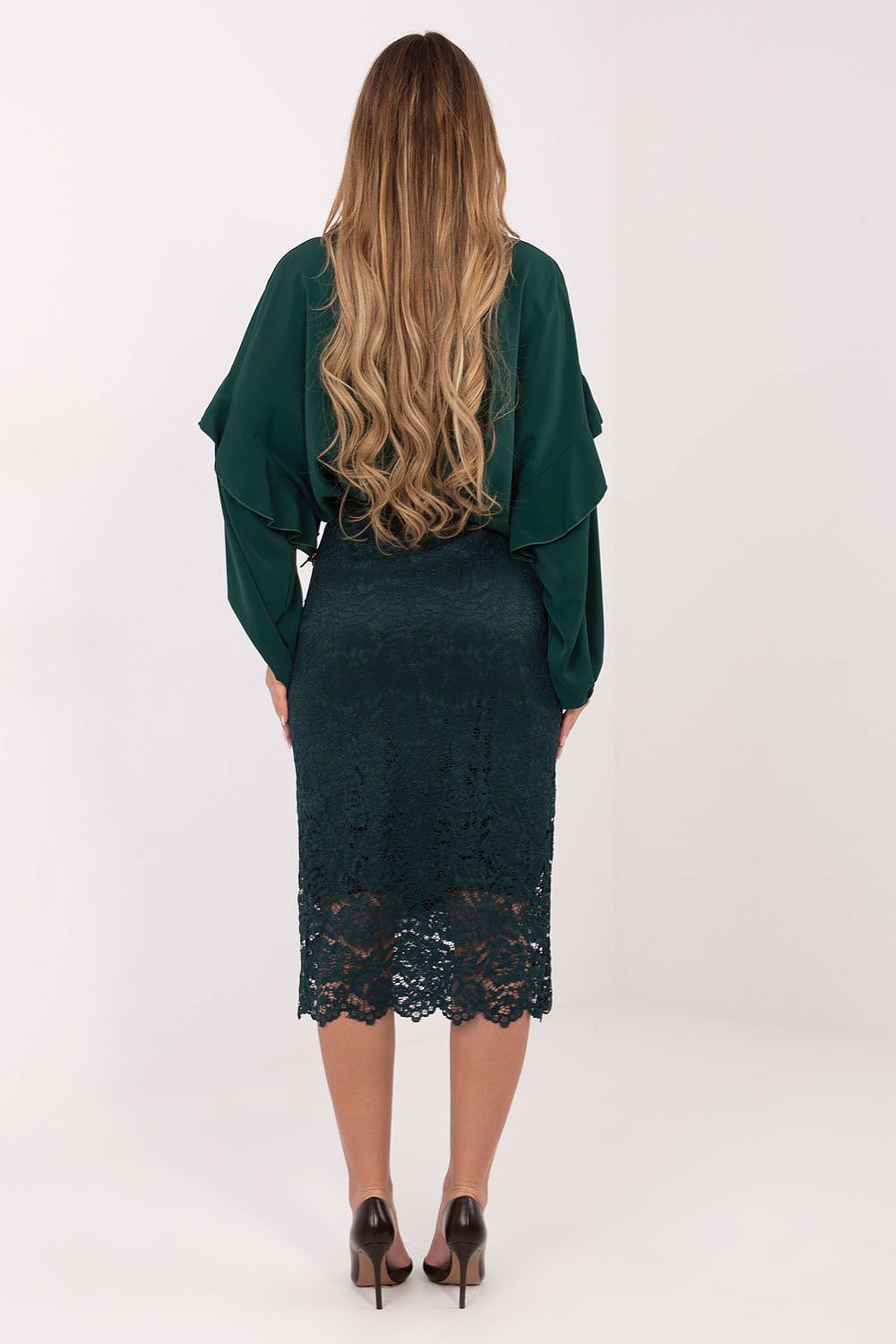 Woman wearing a green lace dress with a matching jacket on a white background