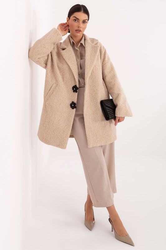 Woman wearing a beige coat with a neutral background