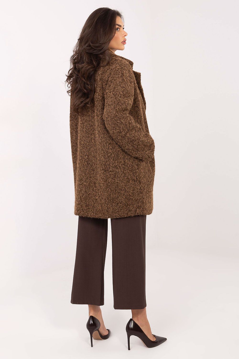 Woman wearing a brown coat and pants on a white background
