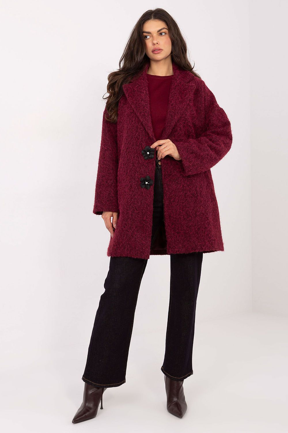 Woman wearing a burgundy coat on a white background