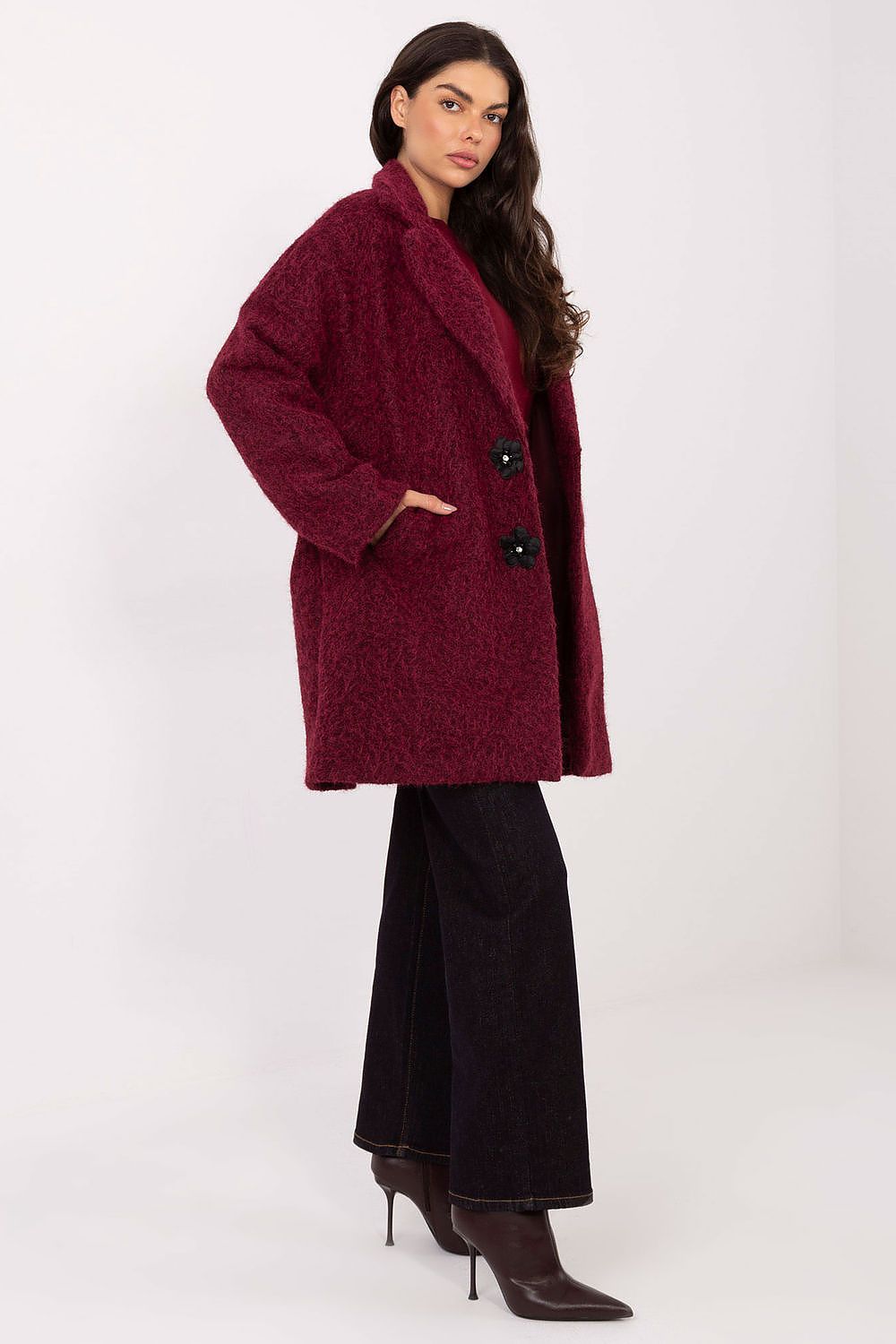 Woman wearing a burgundy coat on a white background