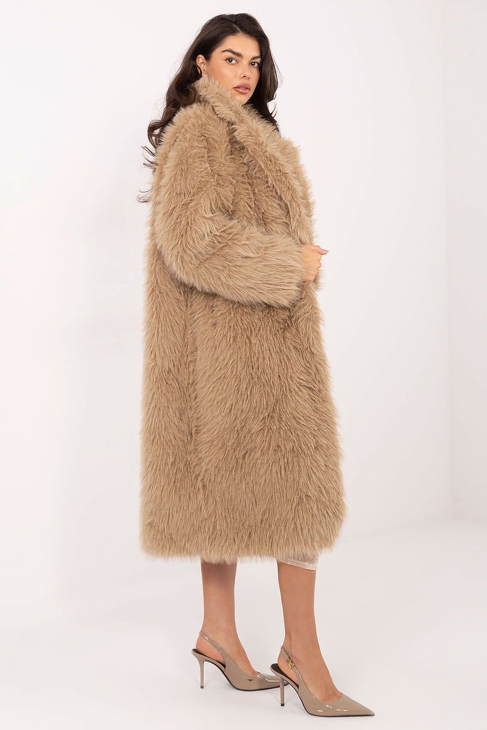 Woman wearing a long beige fur coat on a white background
