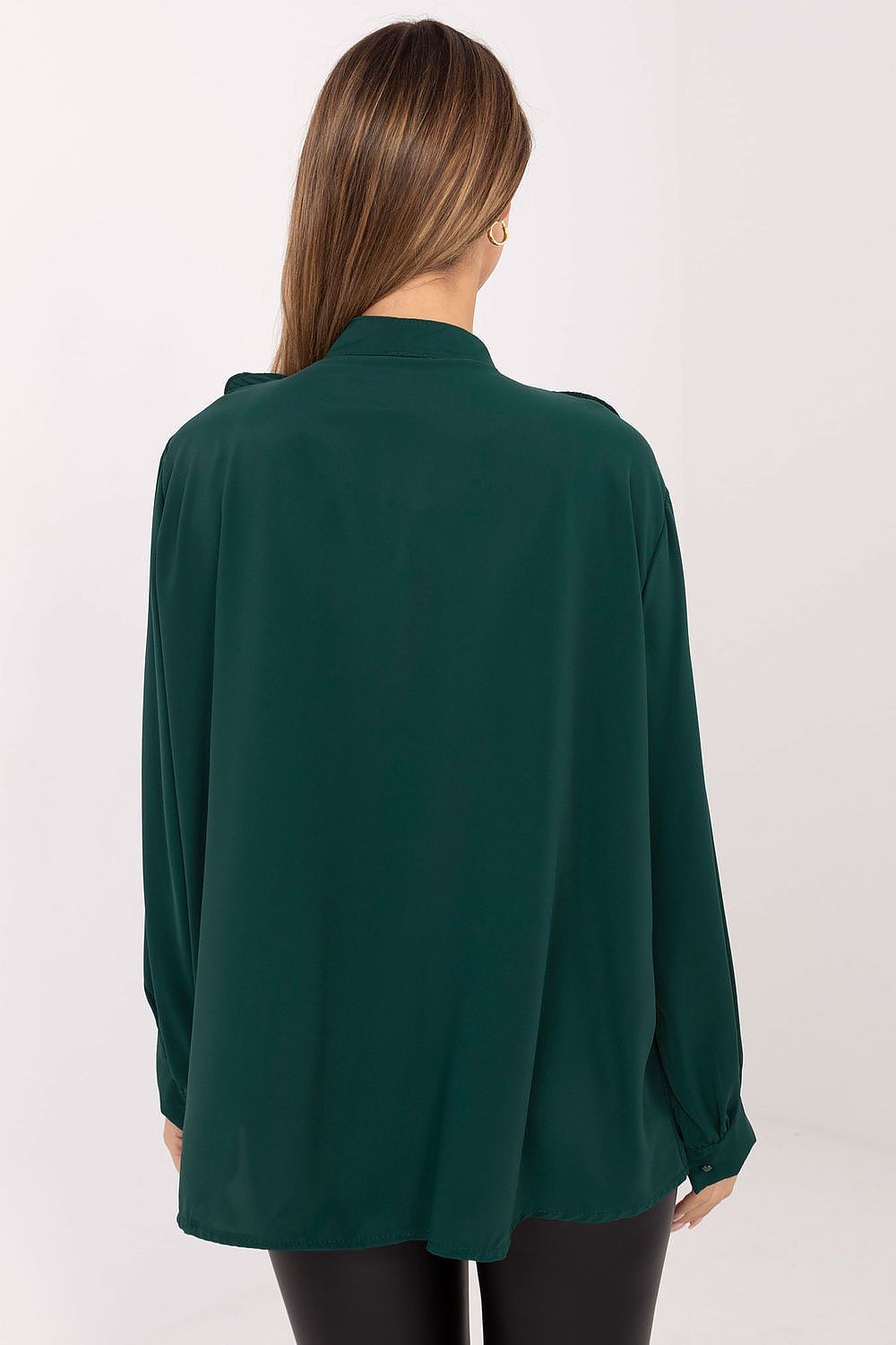 Green blouse worn by a person on a white background