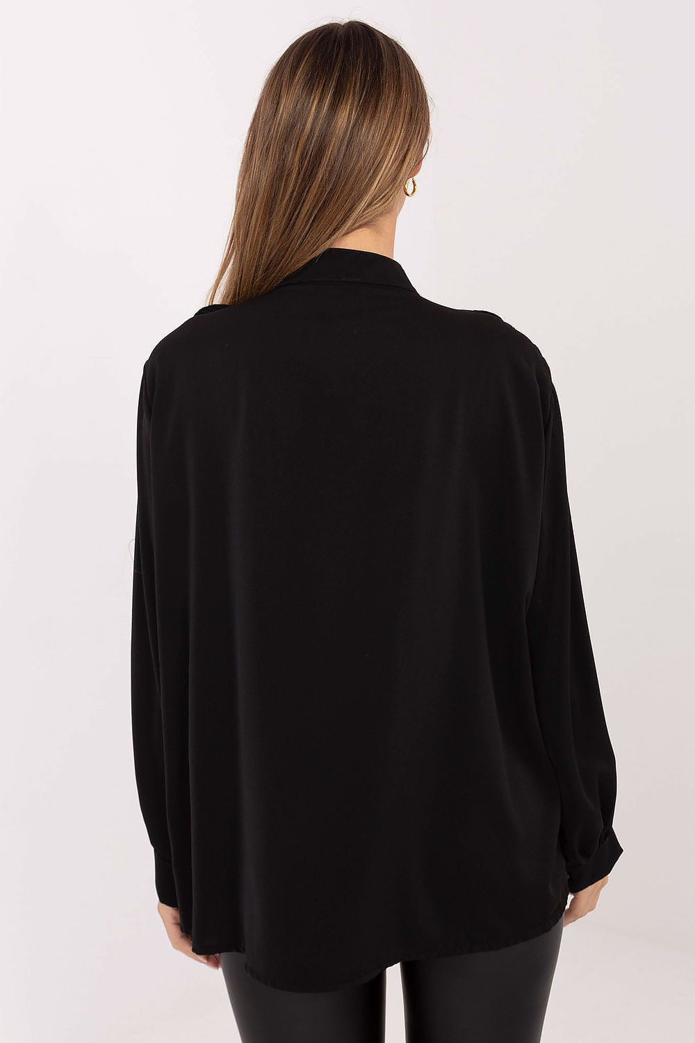 Person wearing a black blouse with long sleeves on a white background