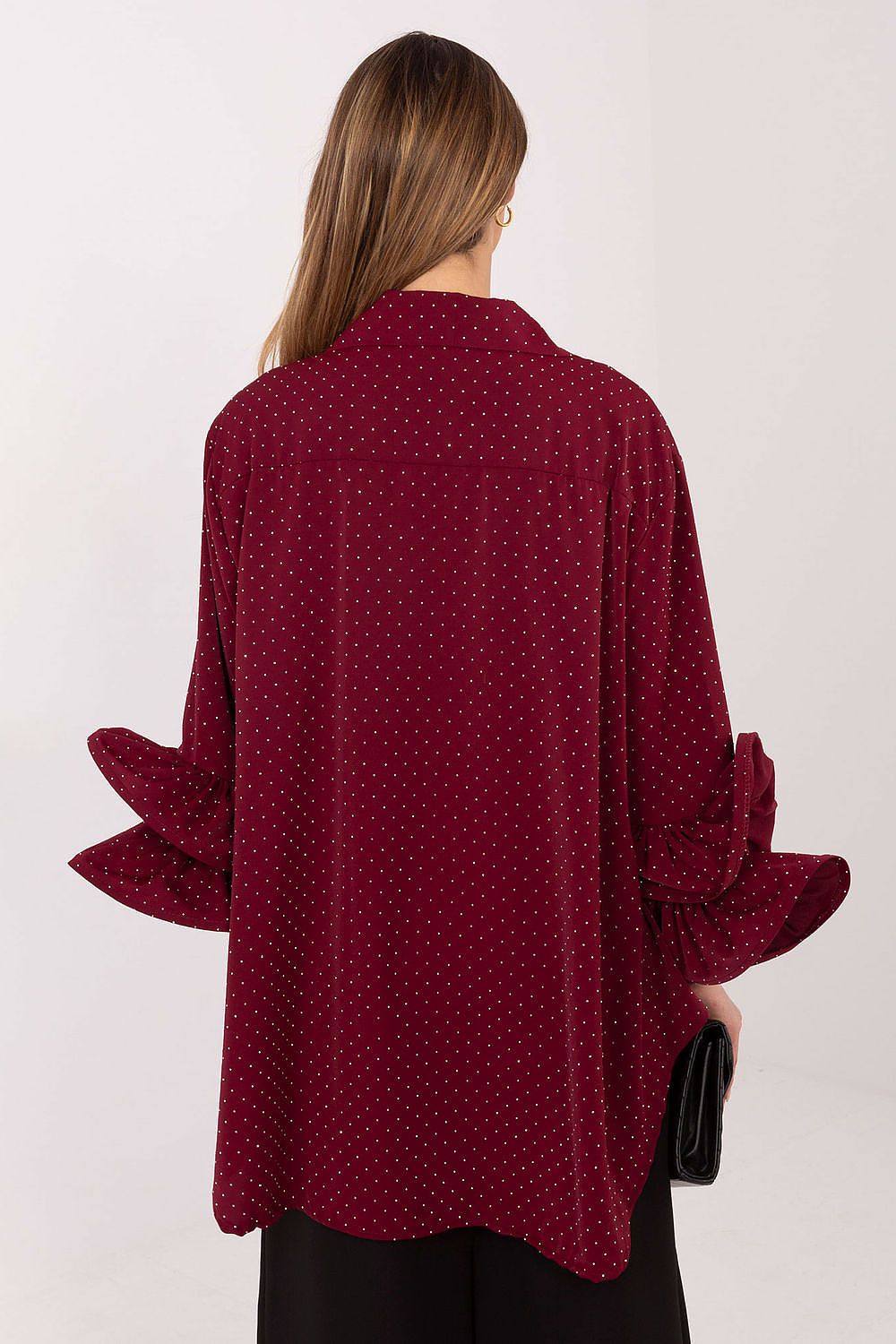 Red polka dot blouse worn by a person on a white background