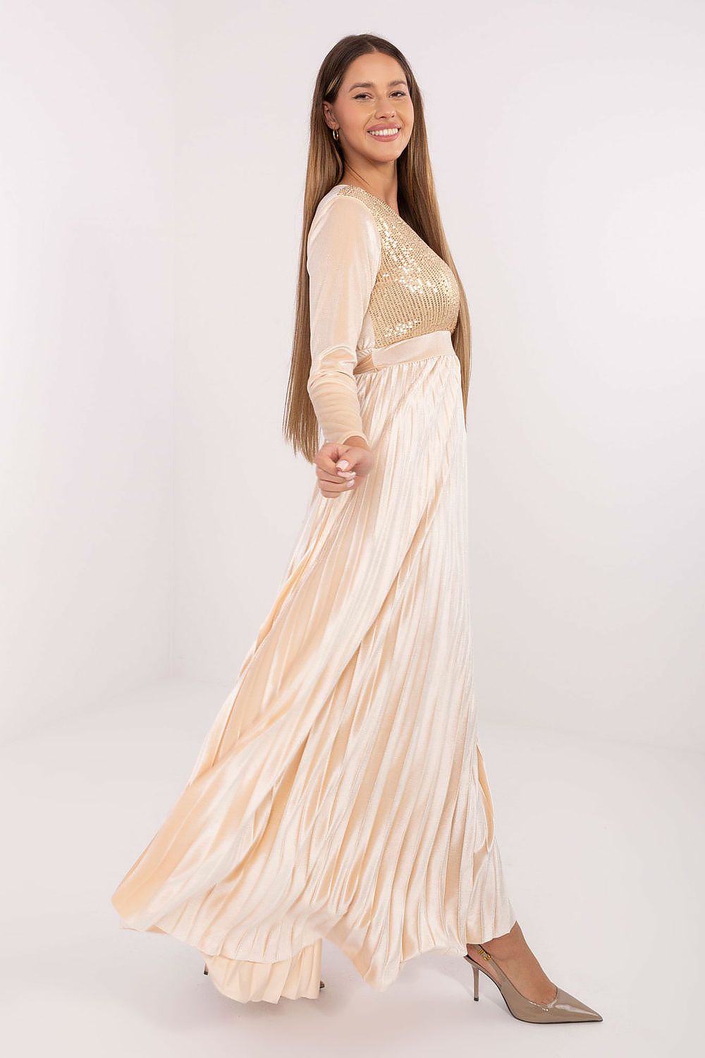 Woman wearing a beige and white dress with long sleeves on a white background