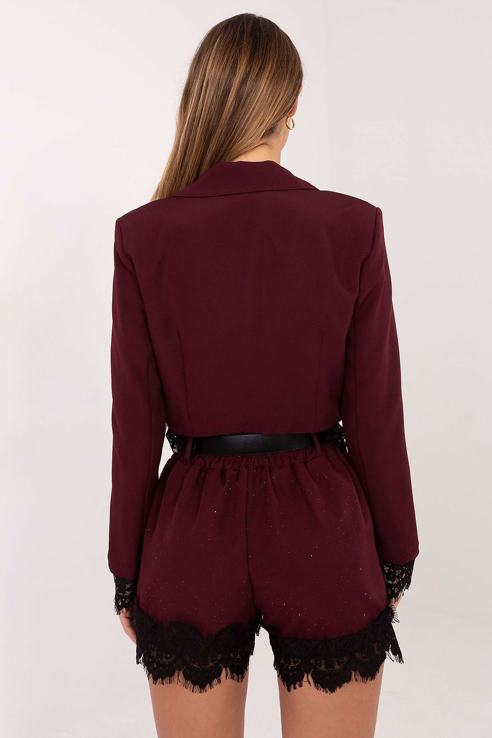 Burgundy romper with lace details on shorts against a white background