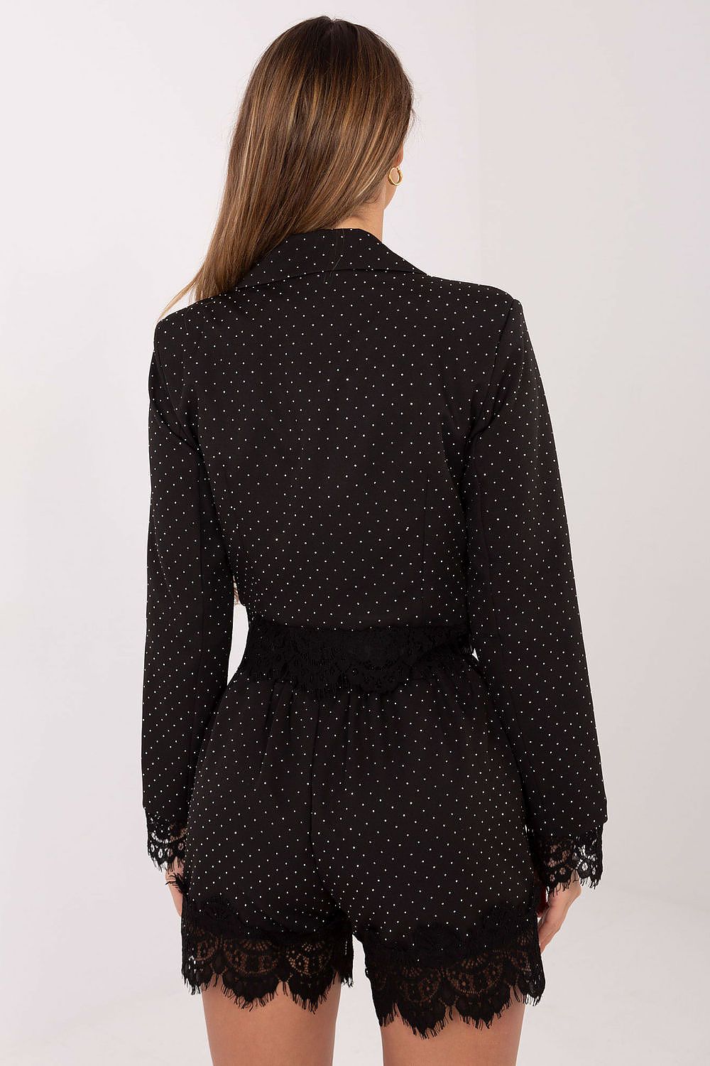 Black polka dot dress with lace details on a white background