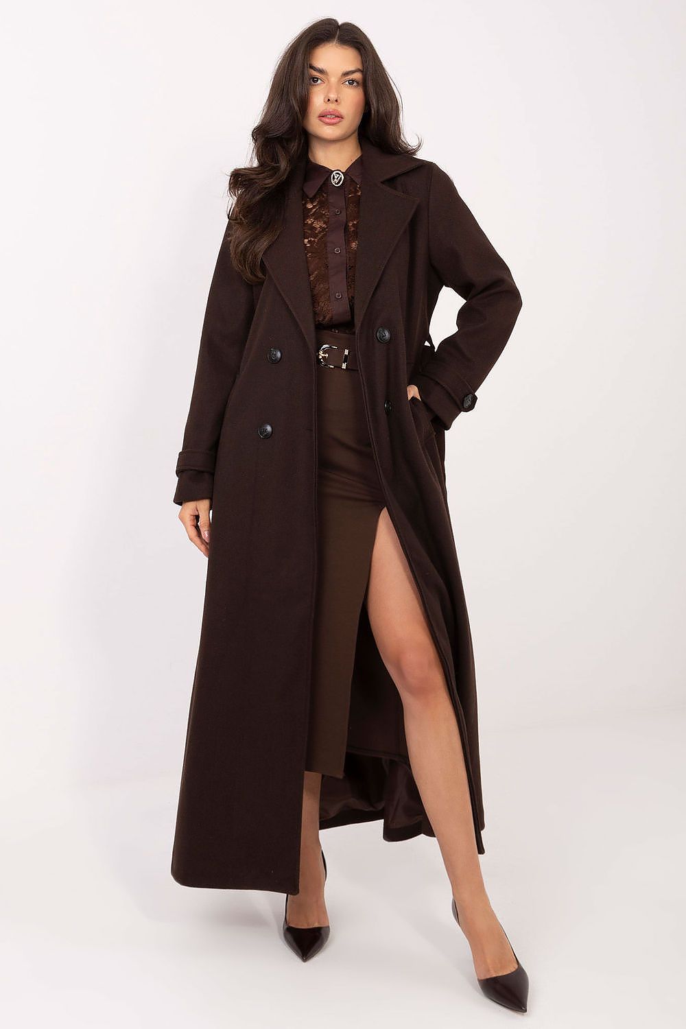 Woman wearing a long brown coat over a brown outfit on a white background