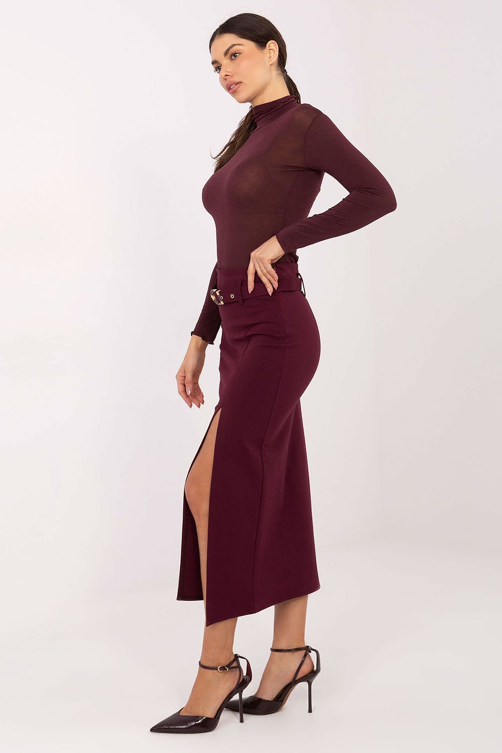 Woman wearing a burgundy dress with a belt on a white background