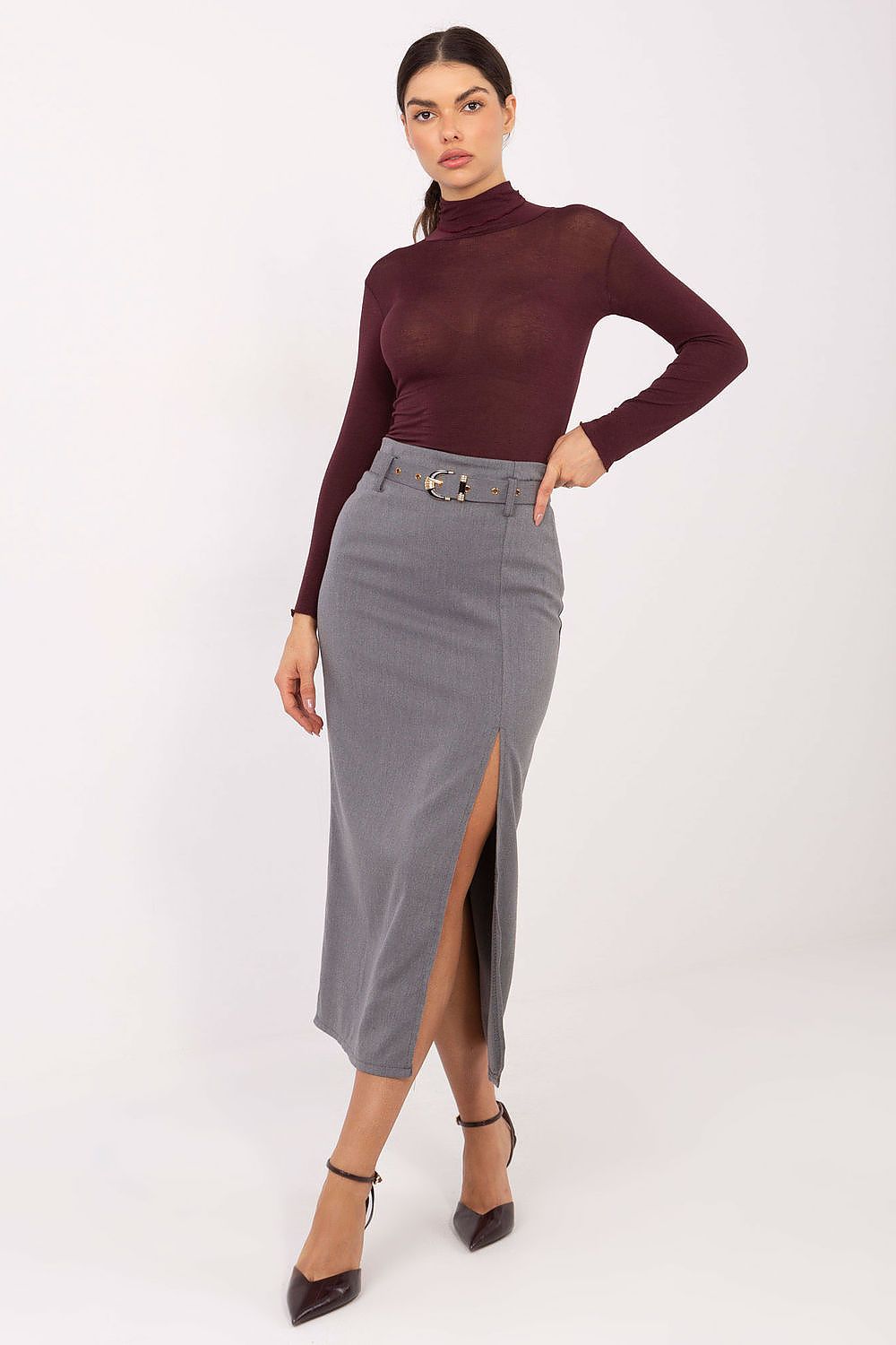 Woman wearing a burgundy turtleneck and gray skirt on a white background