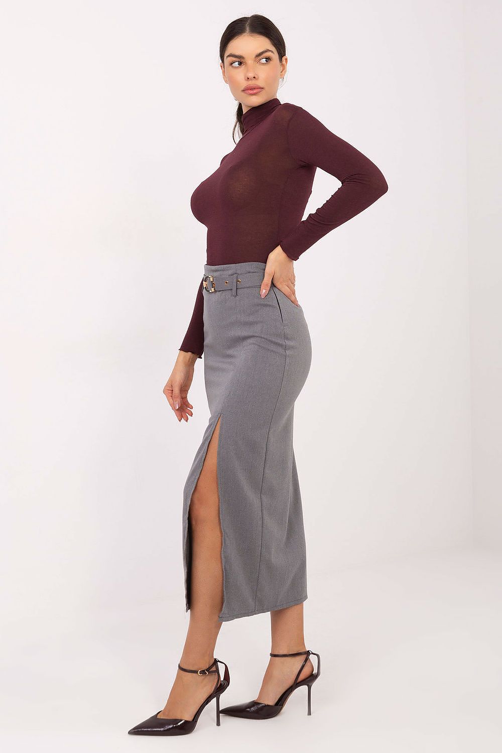 Woman wearing a burgundy top and gray skirt on a white background