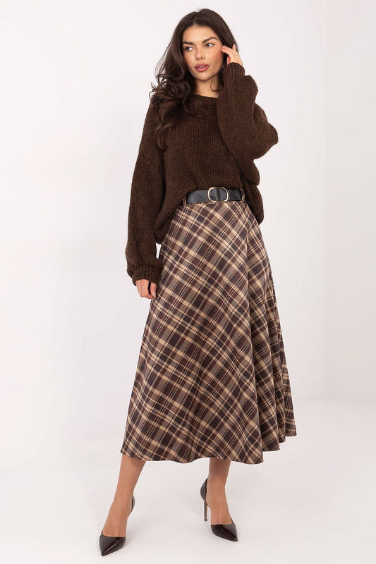 Woman wearing a brown sweater and plaid skirt on a white background