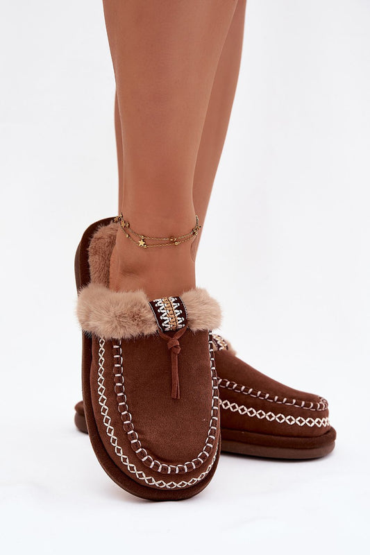 Brown moccasin slippers with fur trim worn by a person on a white background