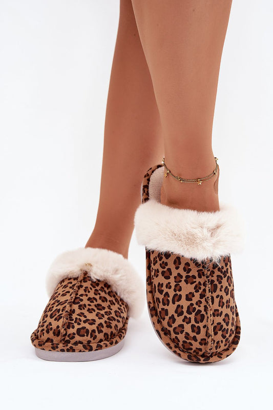 Leopard print slippers with white fur trim worn by a person on a white background