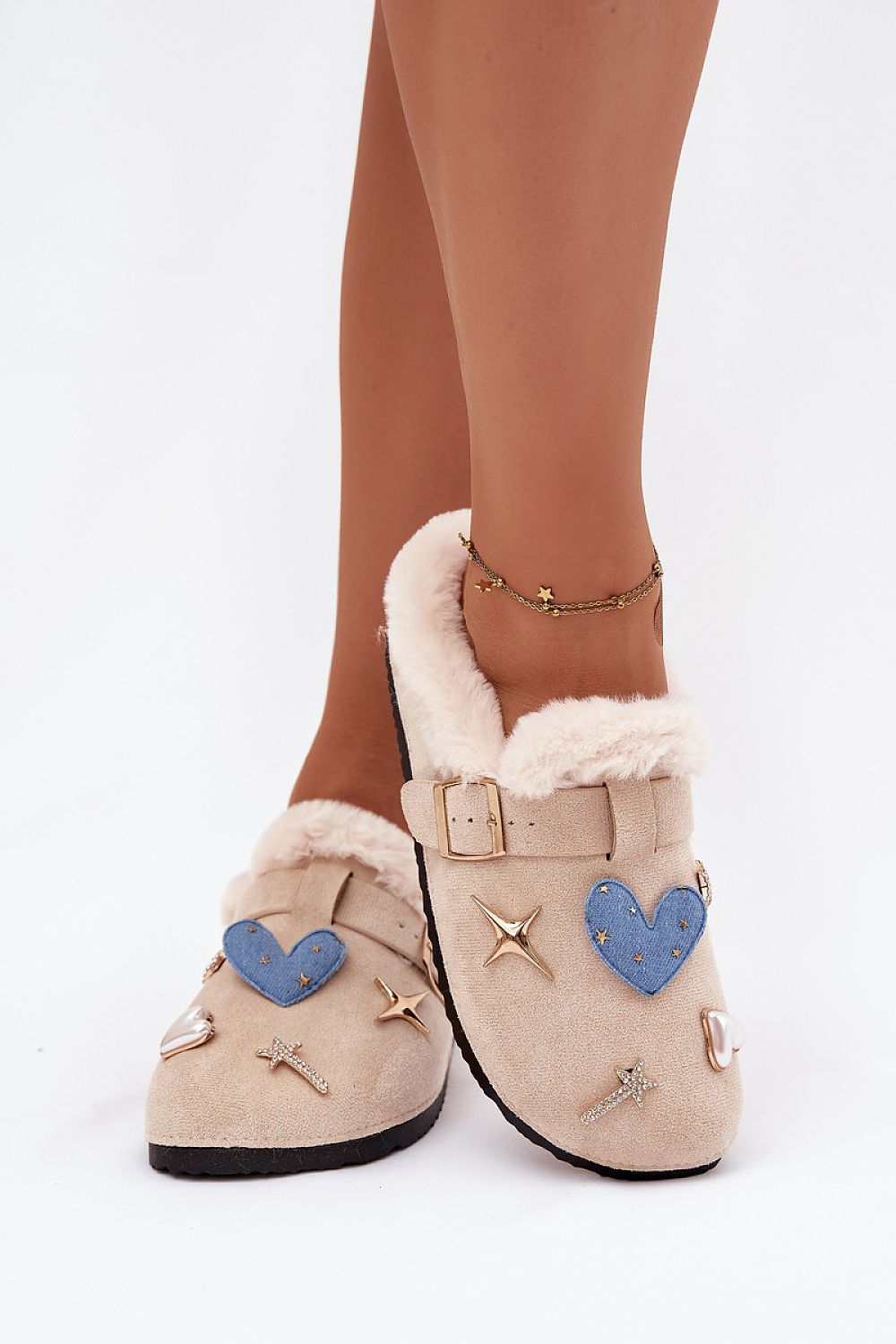 Beige slippers with heart and star decorations on a white background