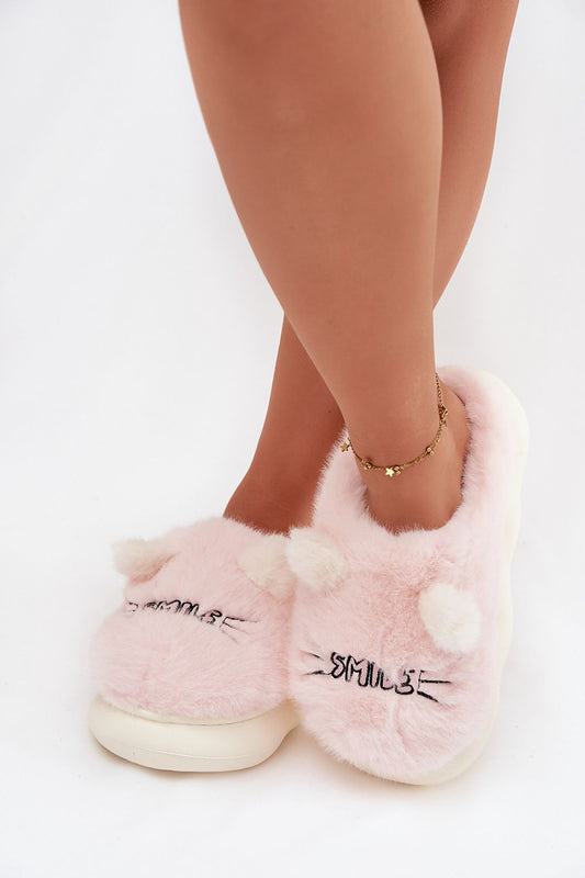 Pink fluffy slippers worn by a person on a white background